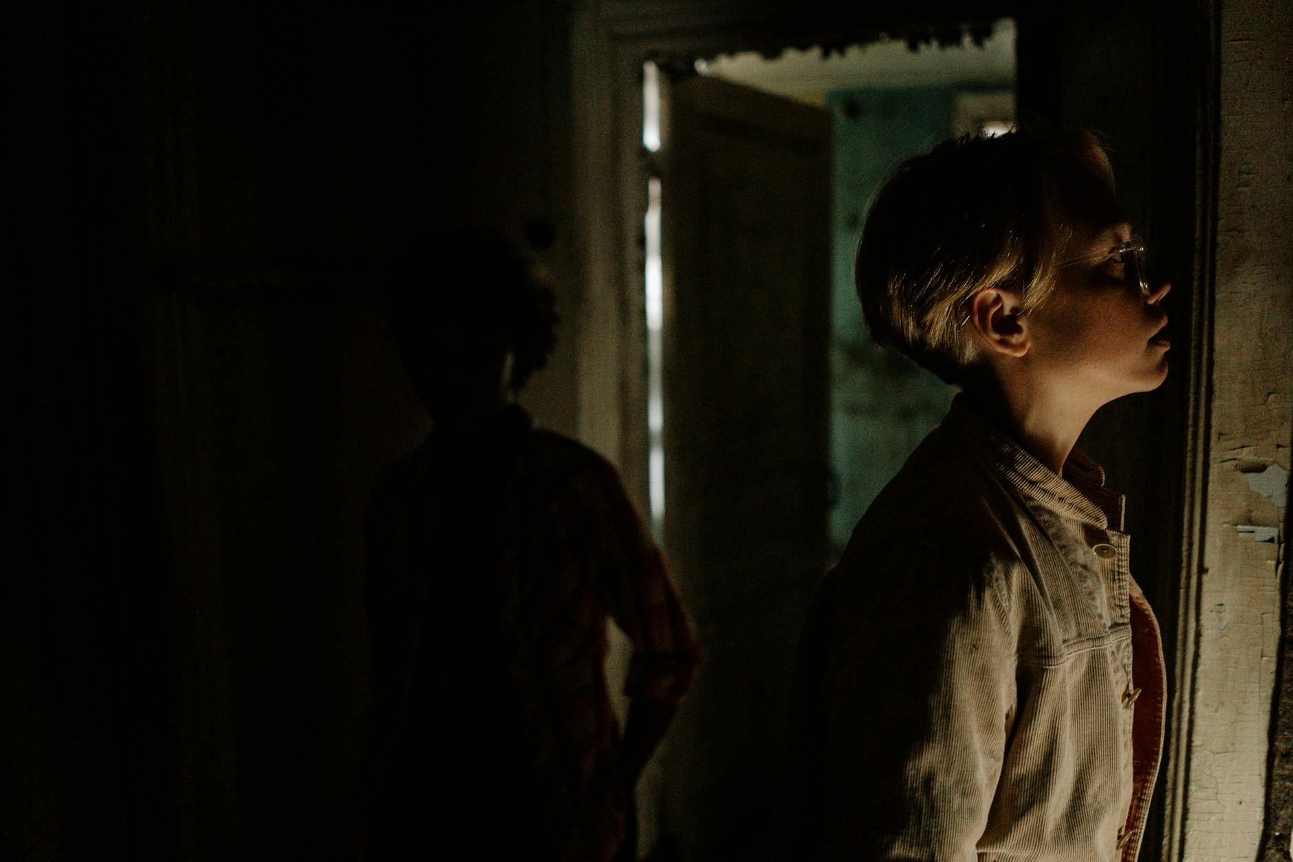 Mroczny opuszczony pokój z cieniami postaci jak w horrorowym escape roomie