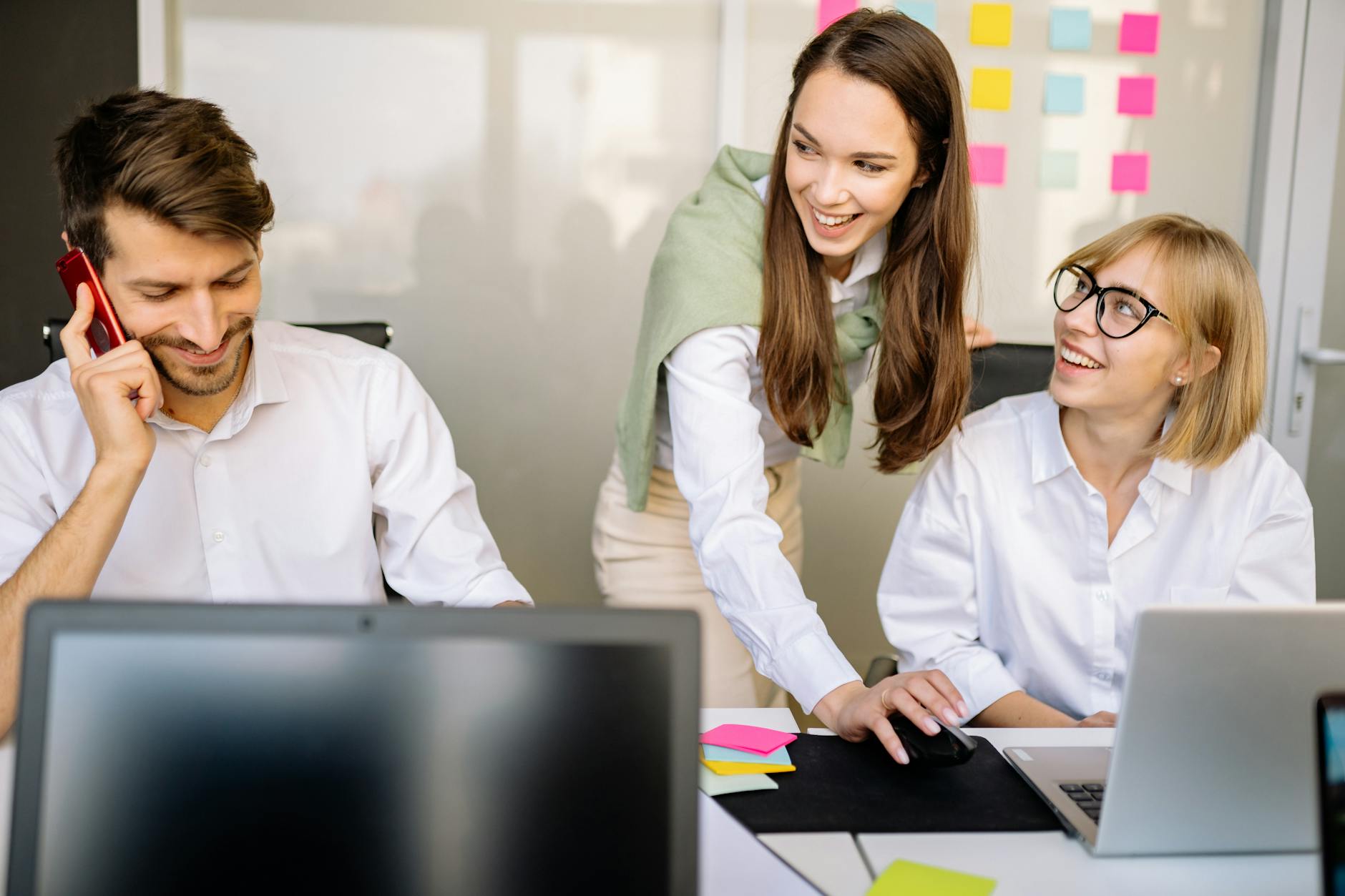 Zespół biurowy omawia strategię przy laptopach w sali konferencyjnej