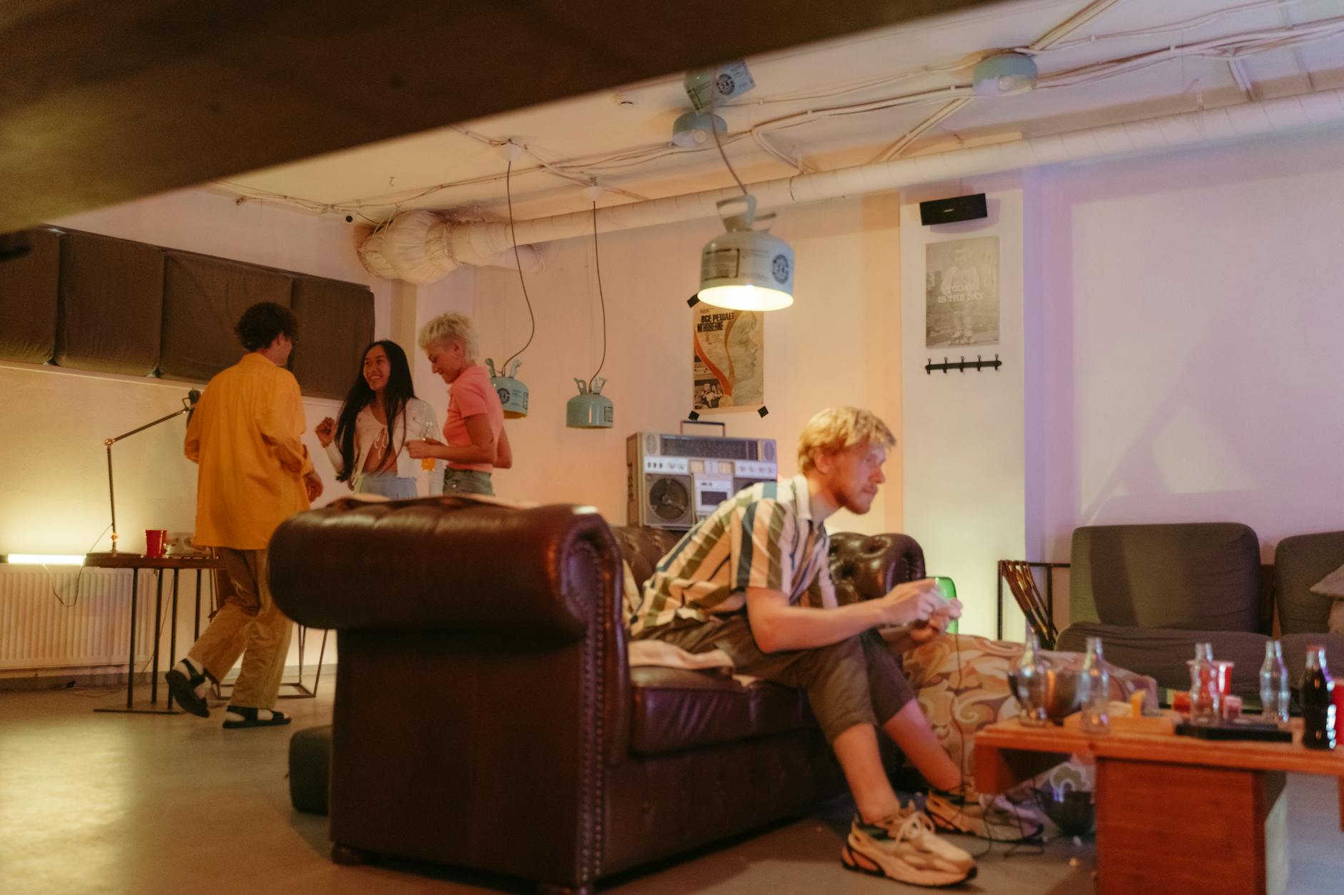 Grupa młodych znajomych rozmawia w przytulnej piwnicy